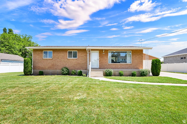2467 South 2000 West Syracuse, UT 84075 - Photo 3 of 28 Brick exterior home featuring a bay window and mature landscaping