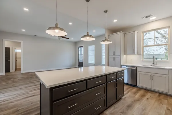 a large kitchen with kitchen island a large island in the center and stainless steel appliances
