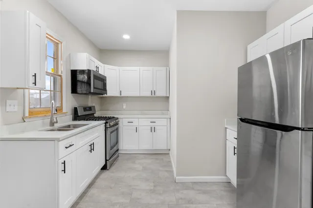 a kitchen with a refrigerator a sink and a stove top oven