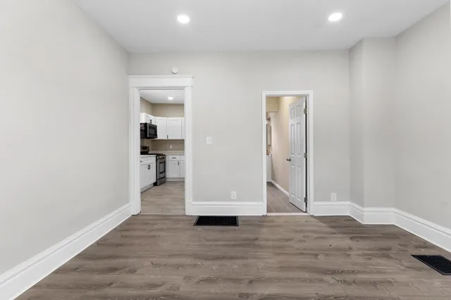 a view of empty room with wooden floor