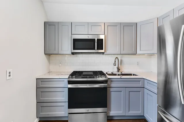 a kitchen with white cabinets and stainless steel appliances