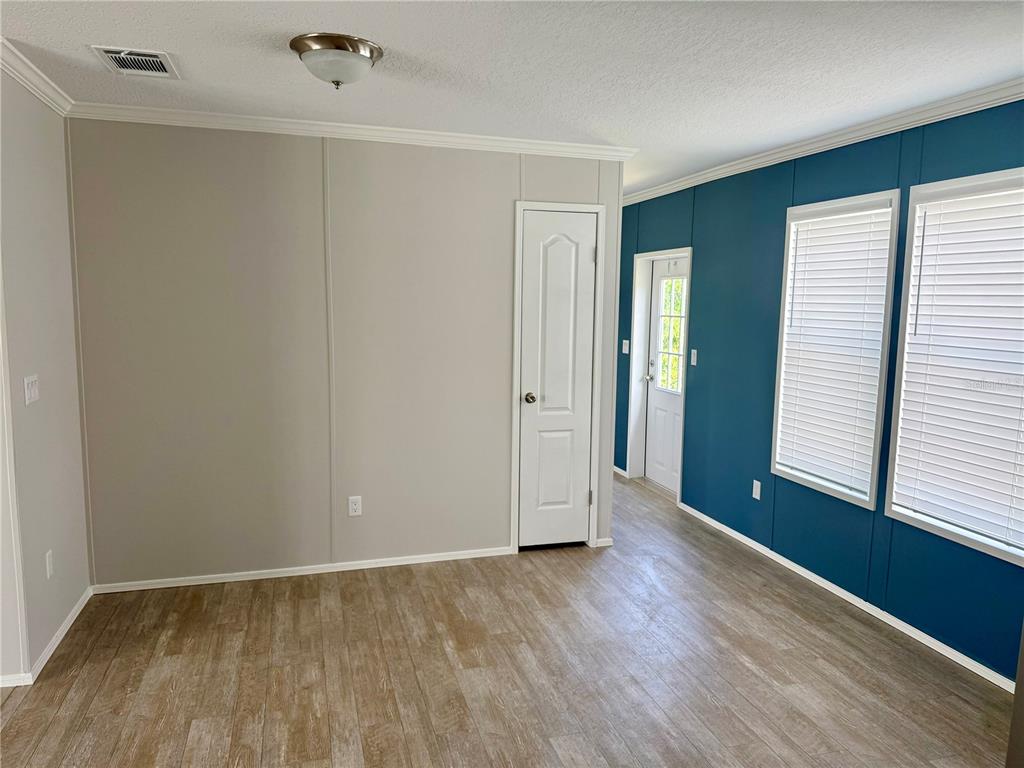 37743 Geiger Road Zephyrhills, FL 33542 - Photo 8 of 21 an empty room with wooden floor and windows