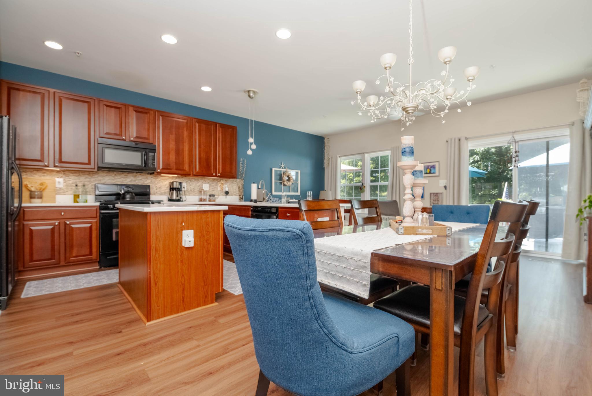 3107 Raking Leaf Drive Abingdon, MD 21009 - Photo 2 of 39 a open dining room with stainless steel appliances kitchen island granite countertop a table chairs and a living room