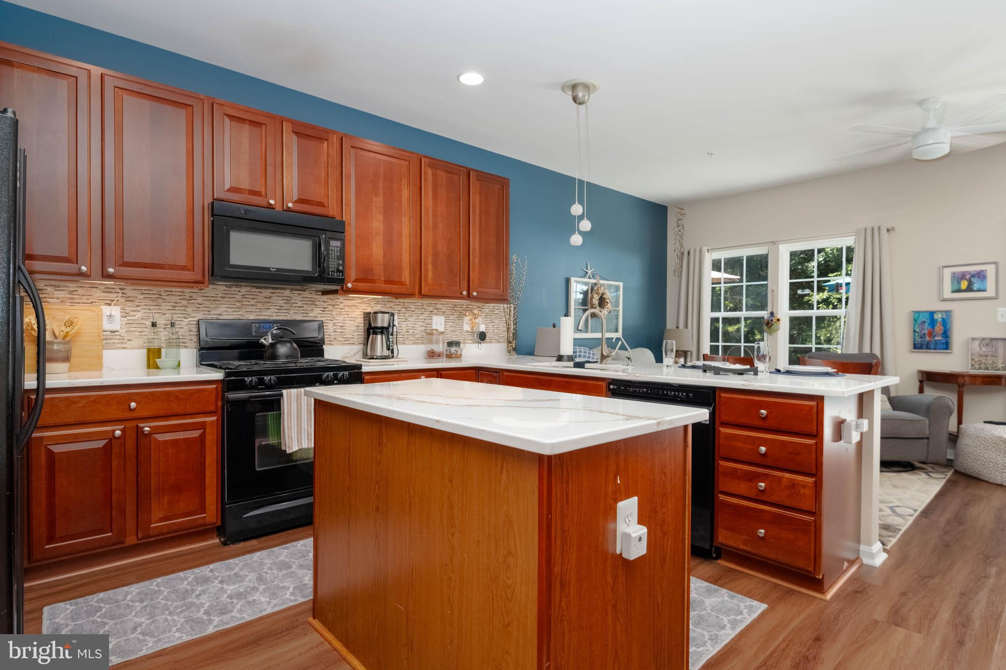 3107 Raking Leaf Drive Abingdon, MD 21009 - Photo 9 of 39 a kitchen with stainless steel appliances granite countertop a stove top oven a sink dishwasher and wooden cabinets with wooden floor