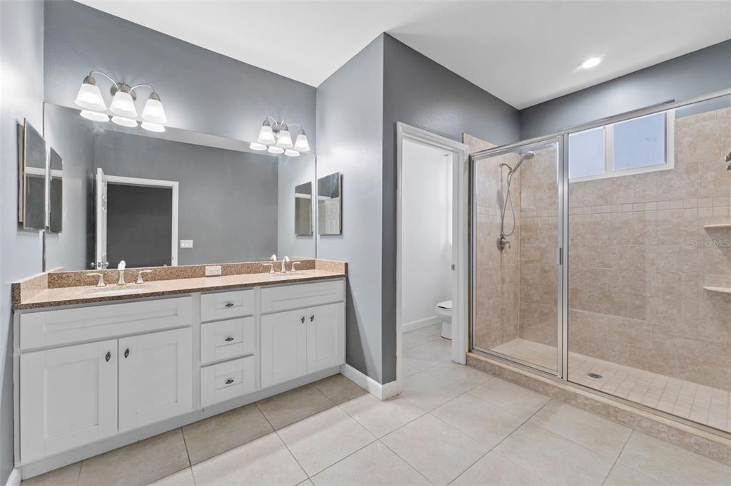 1264 Riserva Lane Palm Harbor, FL 34683 - Photo 13 of 28 a spacious bathroom with a shower a sink and mirror