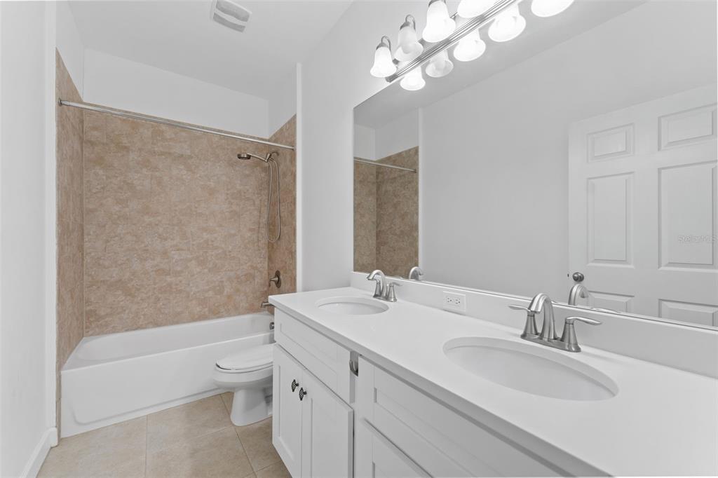 1264 Riserva Lane Palm Harbor, FL 34683 - Photo 18 of 28 a bathroom with a sink a toilet and a large mirror