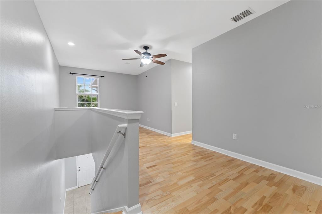 1264 Riserva Lane Palm Harbor, FL 34683 - Photo 8 of 28 wooden floor in an empty room with a window