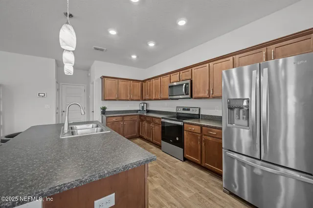 a kitchen with stainless steel appliances granite countertop a refrigerator sink and cabinets