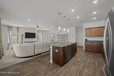 a large kitchen with stainless steel appliances a large counter top and a wooden floors