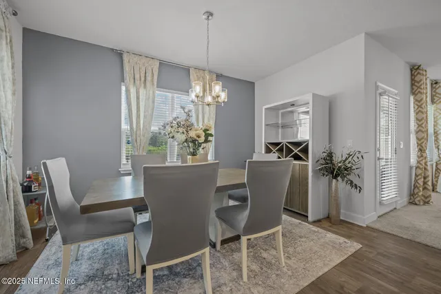 a view of a dining room with furniture and chandelier