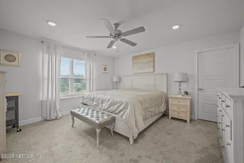 a spacious bedroom with a bed and a chandelier