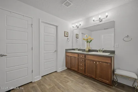 a spacious bathroom with a granite countertop sink a mirror and a vanity