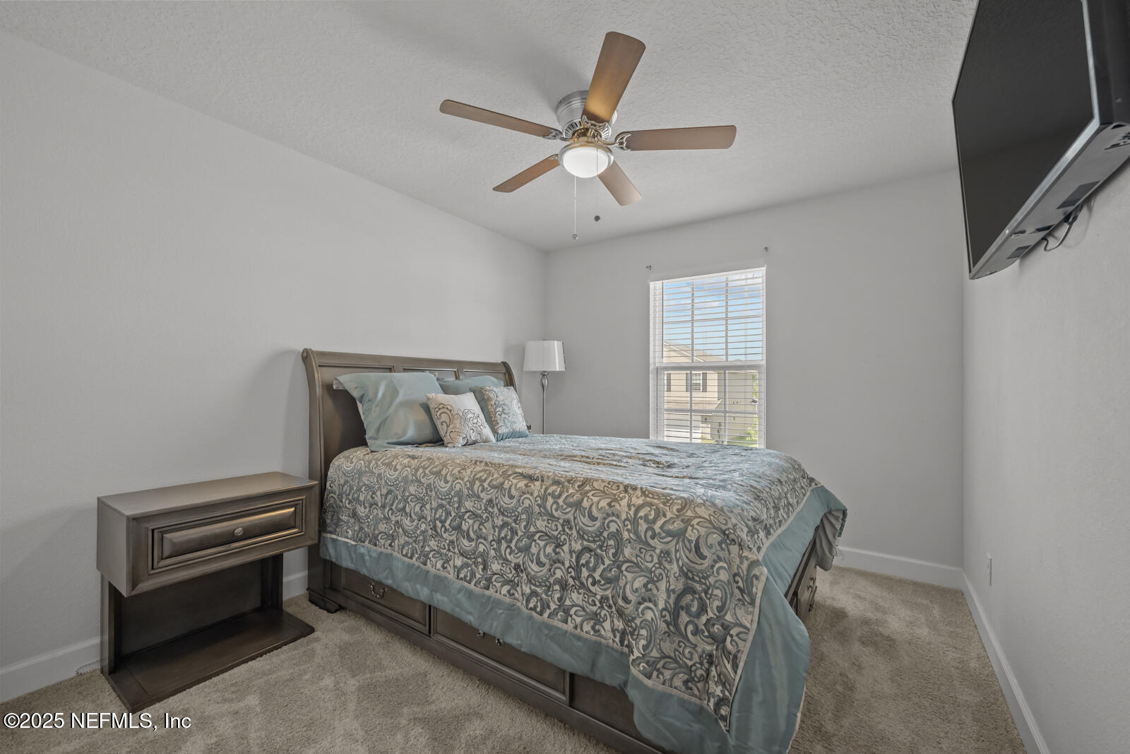 9961 Redfish Marsh Circle Jacksonville, FL 32219 - Photo 26 of 37 a bedroom with a bed next to a window with a chandelier