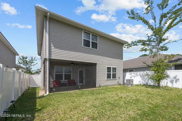 a view of a house with brick walls and a yard with plants
