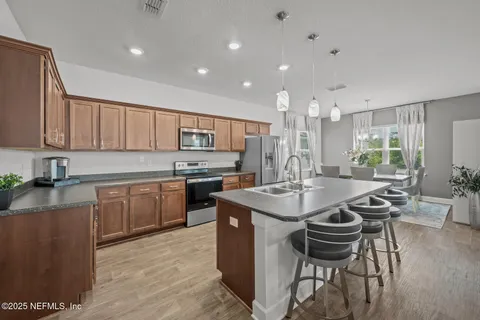 a kitchen with sink a center island and chairs