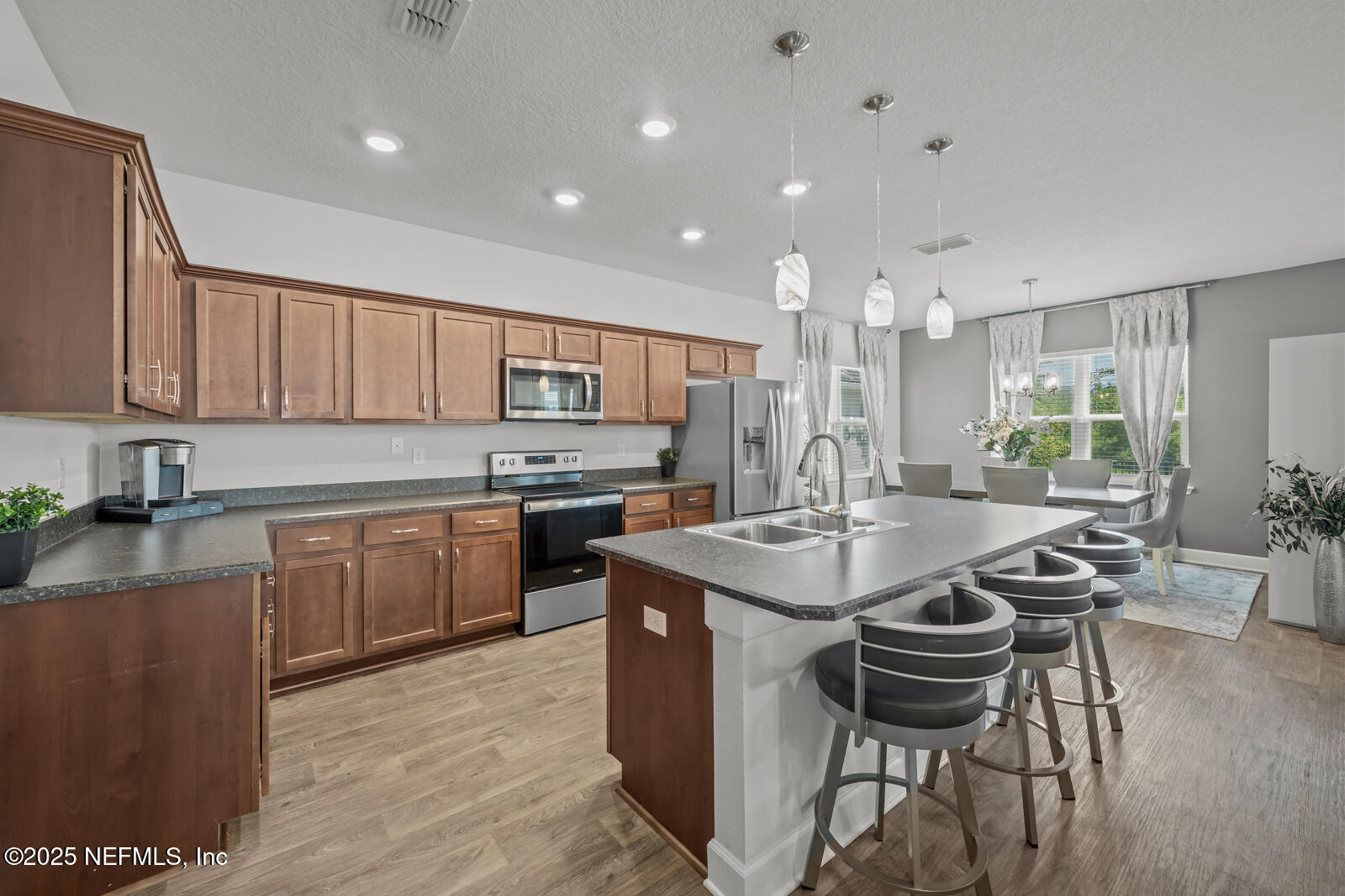 9961 Redfish Marsh Circle Jacksonville, FL 32219 - Photo 10 of 37 a kitchen with sink a center island and chairs