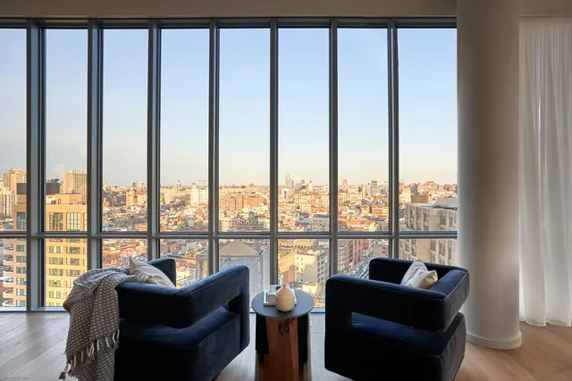 a living room with furniture and floor to ceiling windows