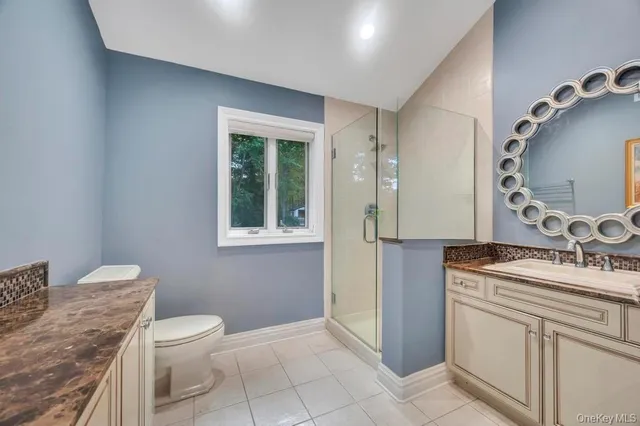 a bathroom with a granite countertop shower a mirror and a sink