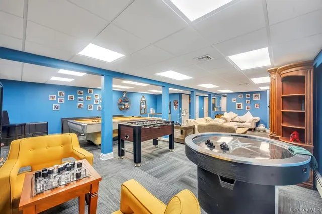 a living room with furniture pool table and a flat screen tv