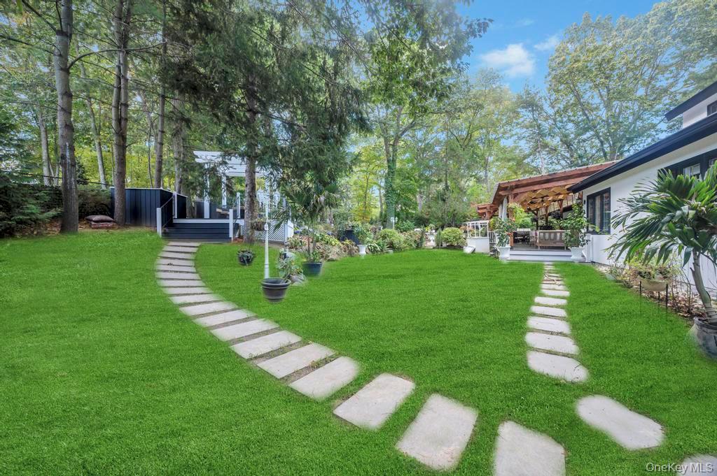 30 Fox Hollow Ridings Road Northport, NY 11768 - Photo 45 of 50 a front view of a house with a yard table and chairs