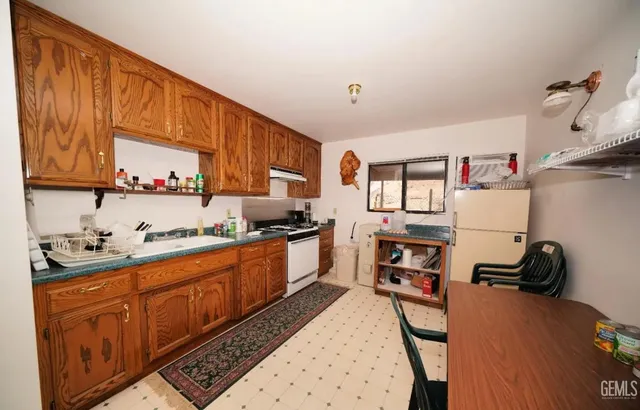 a kitchen with granite countertop a sink stove and cabinets