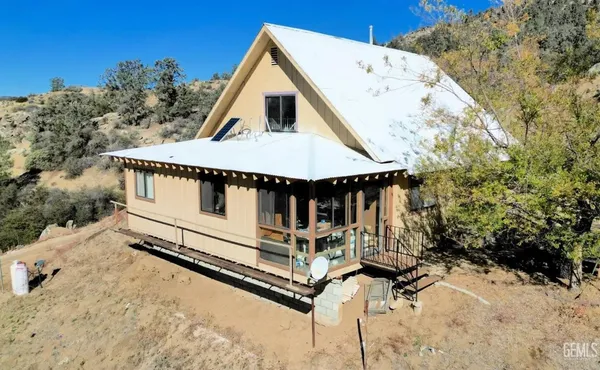 a view of a small house with wooden deck