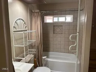 a bathroom with a bathtub a window and a shower