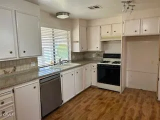 a kitchen with granite countertop white cabinets and appliances