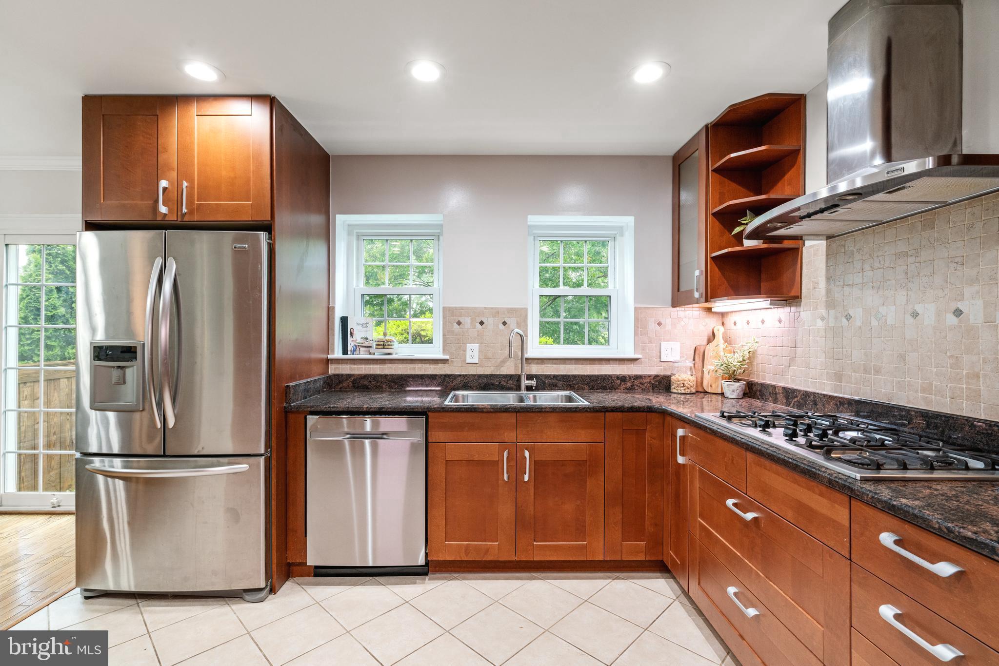 2192 Golf Course Drive Reston, VA 20191 - Photo 12 of 125 a kitchen with stainless steel appliances granite countertop a refrigerator a sink dishwasher a stove and a dining table with wooden floor