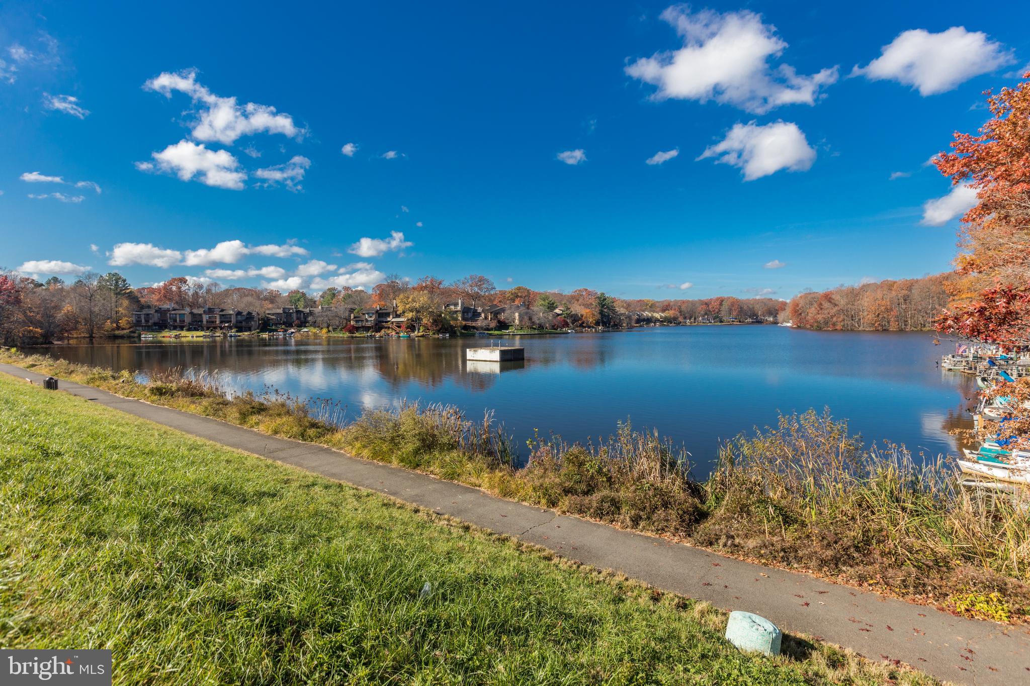 2192 Golf Course Drive Reston, VA 20191 - Photo 66 of 125 a view of a lake with lawn chairs under an umbrella