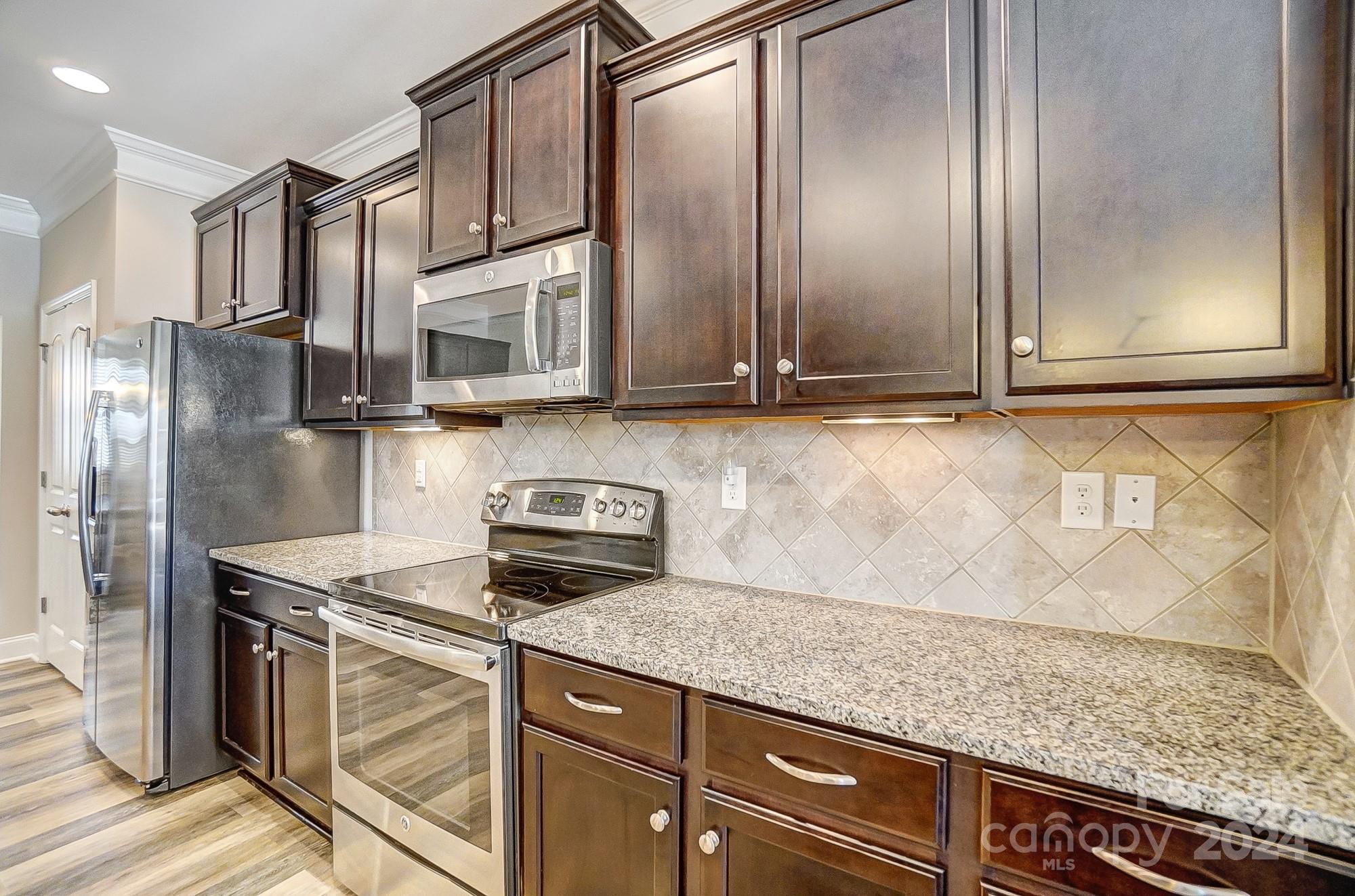 156 Annatto Way Tega Cay, SC 29708 - Photo 15 of 48 a kitchen with kitchen island granite countertop cabinets and stainless steel appliances