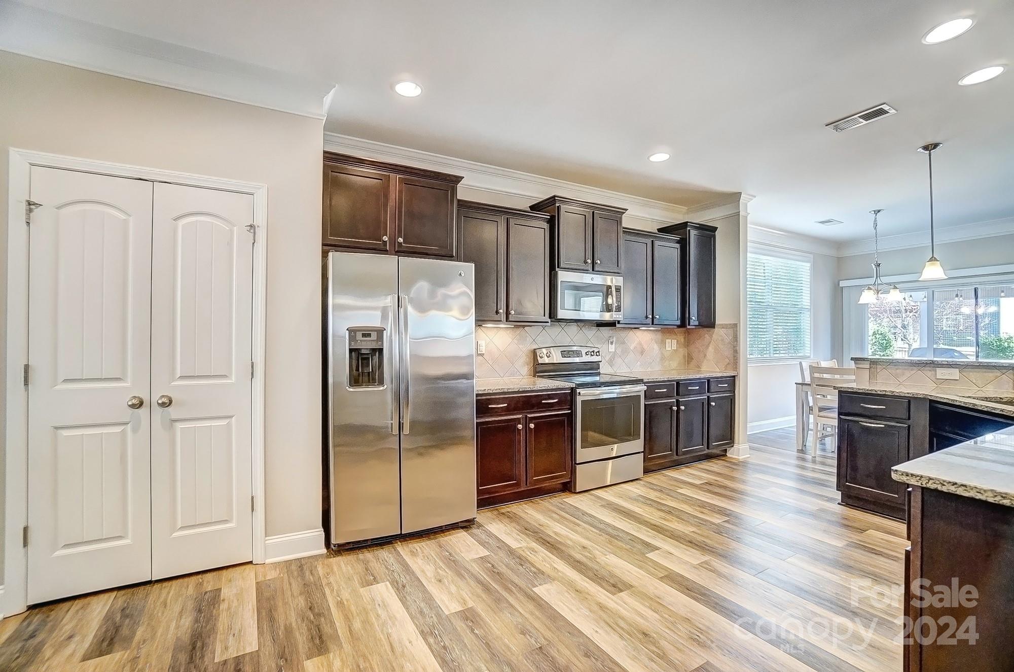 156 Annatto Way Tega Cay, SC 29708 - Photo 16 of 48 a kitchen with stainless steel appliances granite countertop a refrigerator and a stove top oven