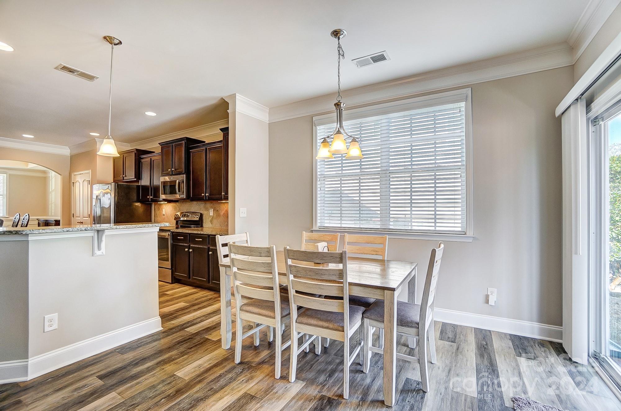 156 Annatto Way Tega Cay, SC 29708 - Photo 17 of 48 a view of a dining room with furniture window and wooden floor