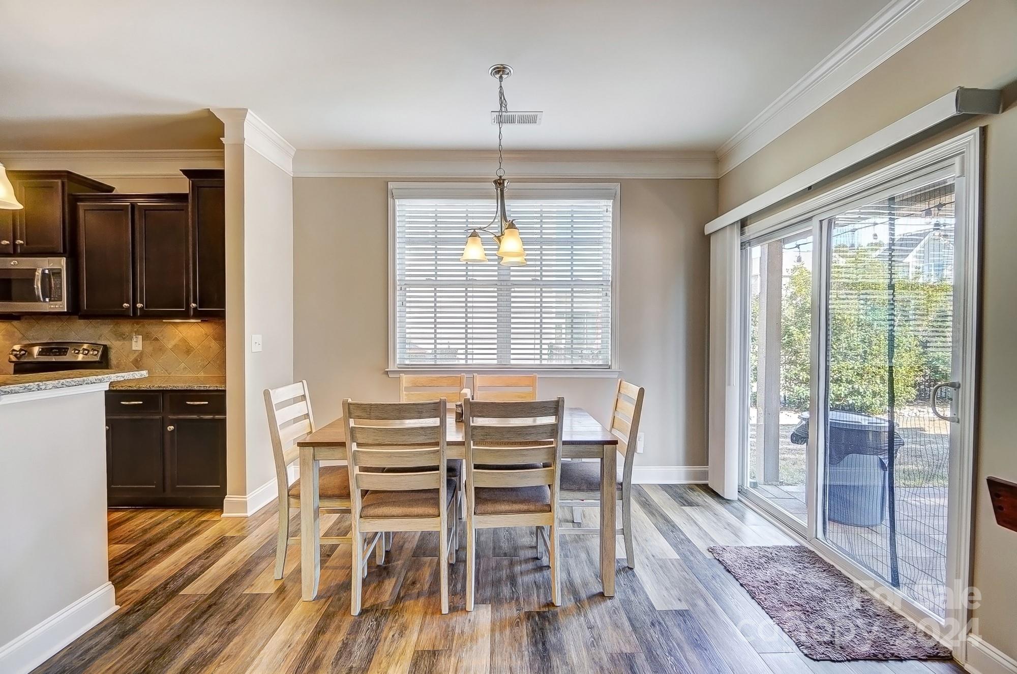 156 Annatto Way Tega Cay, SC 29708 - Photo 19 of 48 a view of a dining room with furniture window and wooden floor