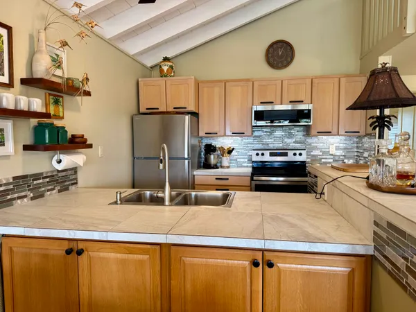 a kitchen with stainless steel appliances granite countertop a sink stove and refrigerator