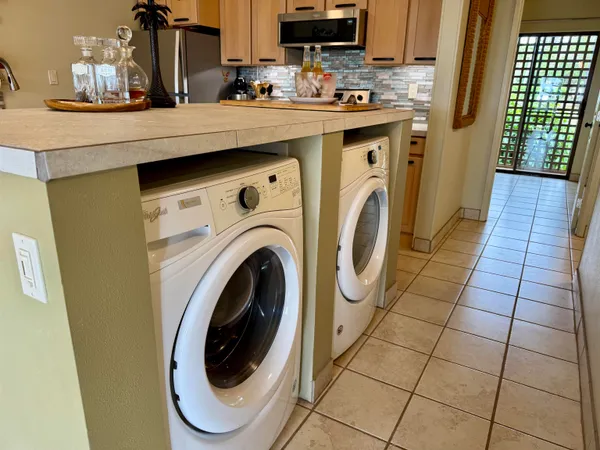 a utility room with dryer washer and a view of living room