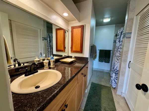 a bathroom with a granite countertop sink and a mirror