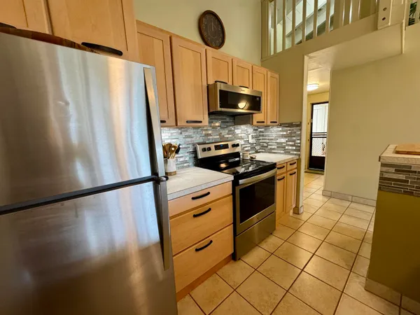 a kitchen with stainless steel appliances granite countertop a sink a stove and a refrigerator