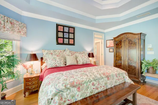 a bedroom with a bed and large windows