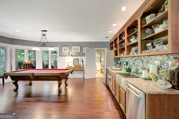 a room with pool table and windows