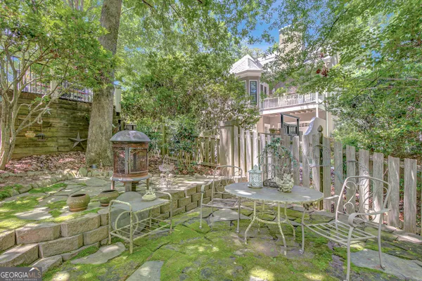 a backyard with chairs and large trees