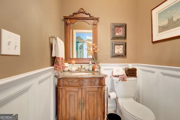 a bathroom with a granite countertop toilet sink and mirror
