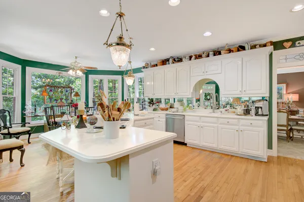 a kitchen with stainless steel appliances kitchen island a large window a sink and cabinets