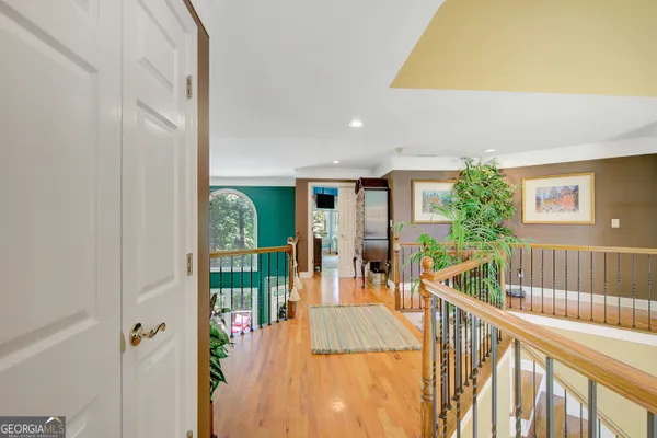 a view of a hallway with wooden floor door and windows