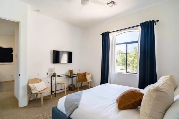 a bedroom with a bed and a flat screen tv