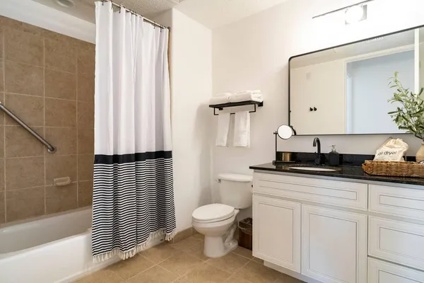 a bathroom with a granite countertop sink toilet and shower