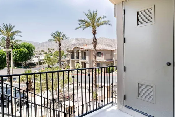 a view of a palm trees from a balcony
