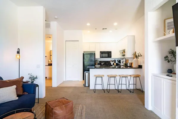 a living room with furniture and kitchen view