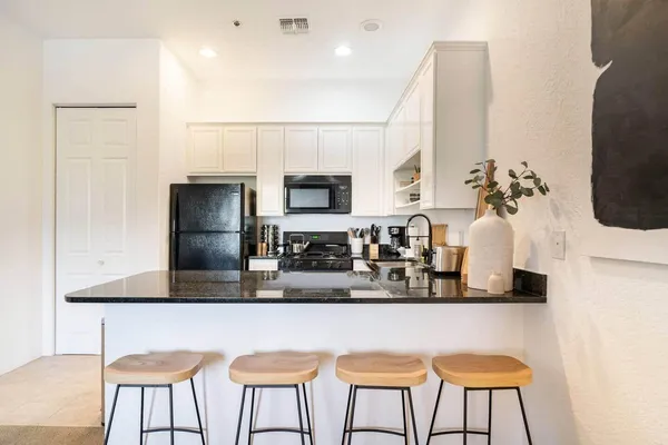a kitchen with stainless steel appliances kitchen island granite countertop a table and chairs in it