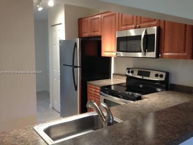 a kitchen with stainless steel appliances a stove a microwave and a refrigerator